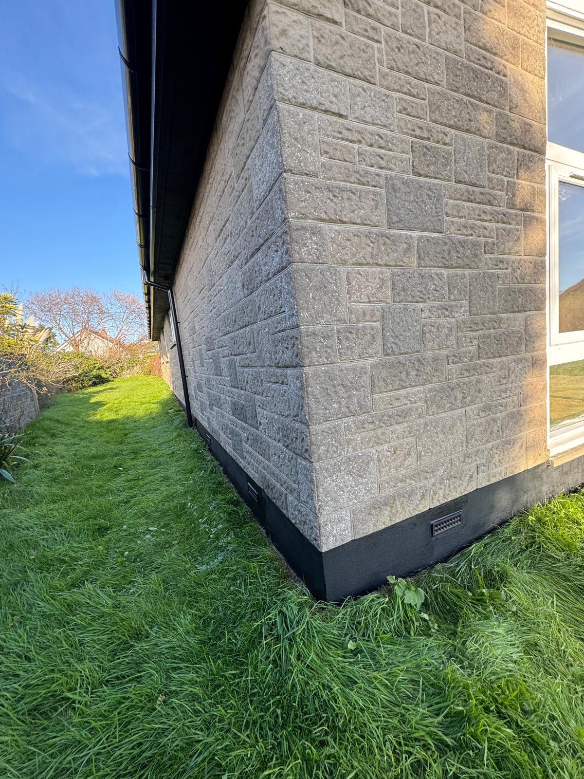 Close-up of exterior stone wall corner showing detailed masonry work