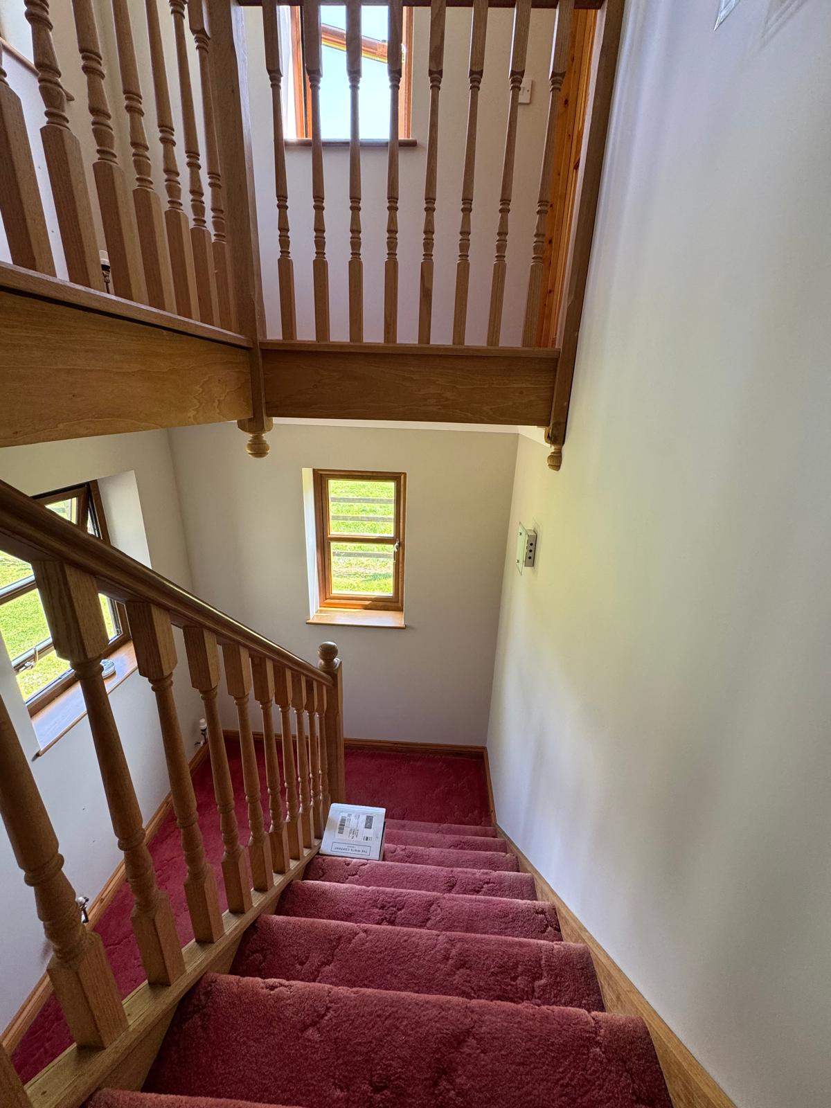Wooden staircase from below with white walls
