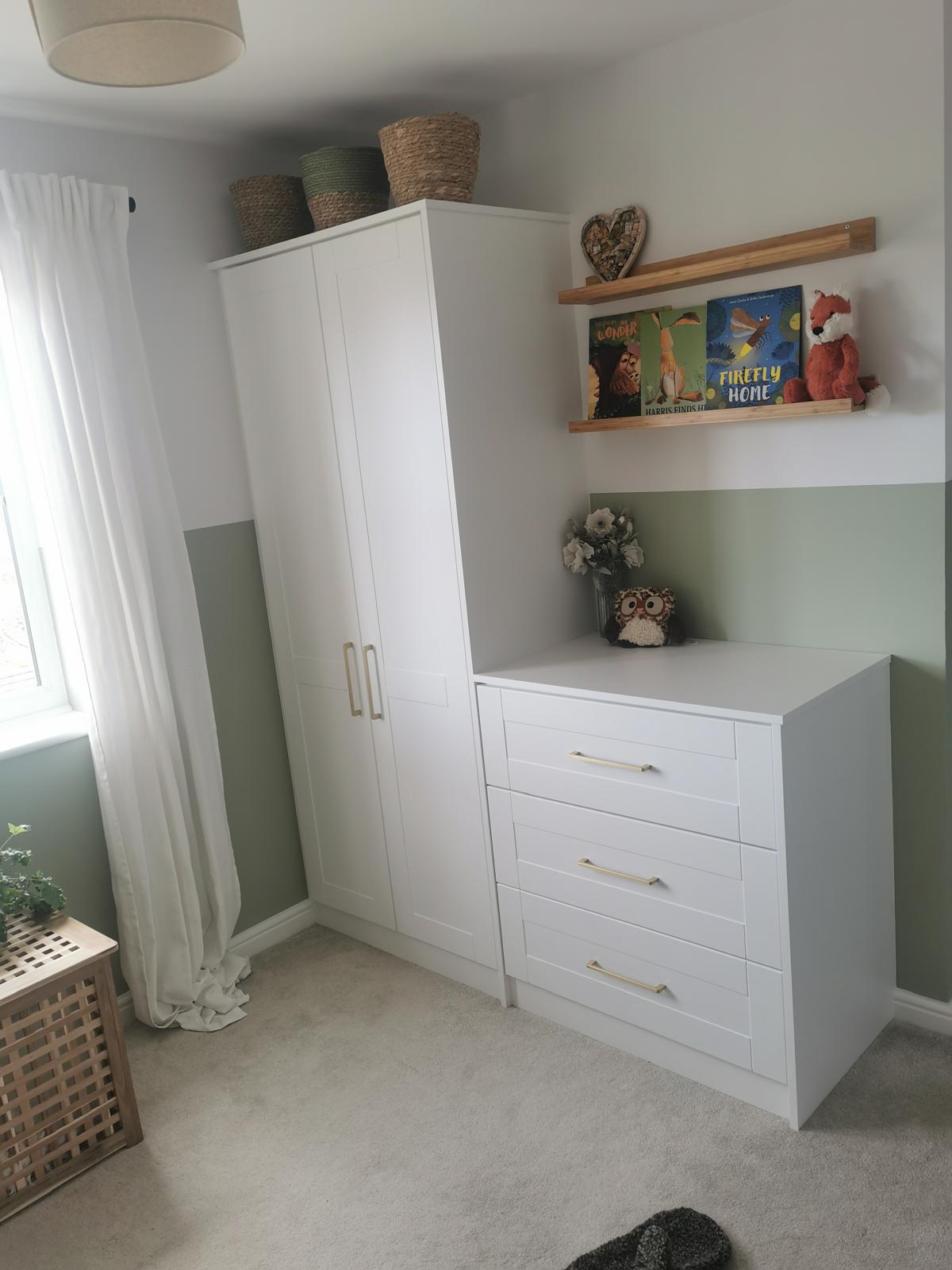 Child's room with sage green feature wall and white built-in storage