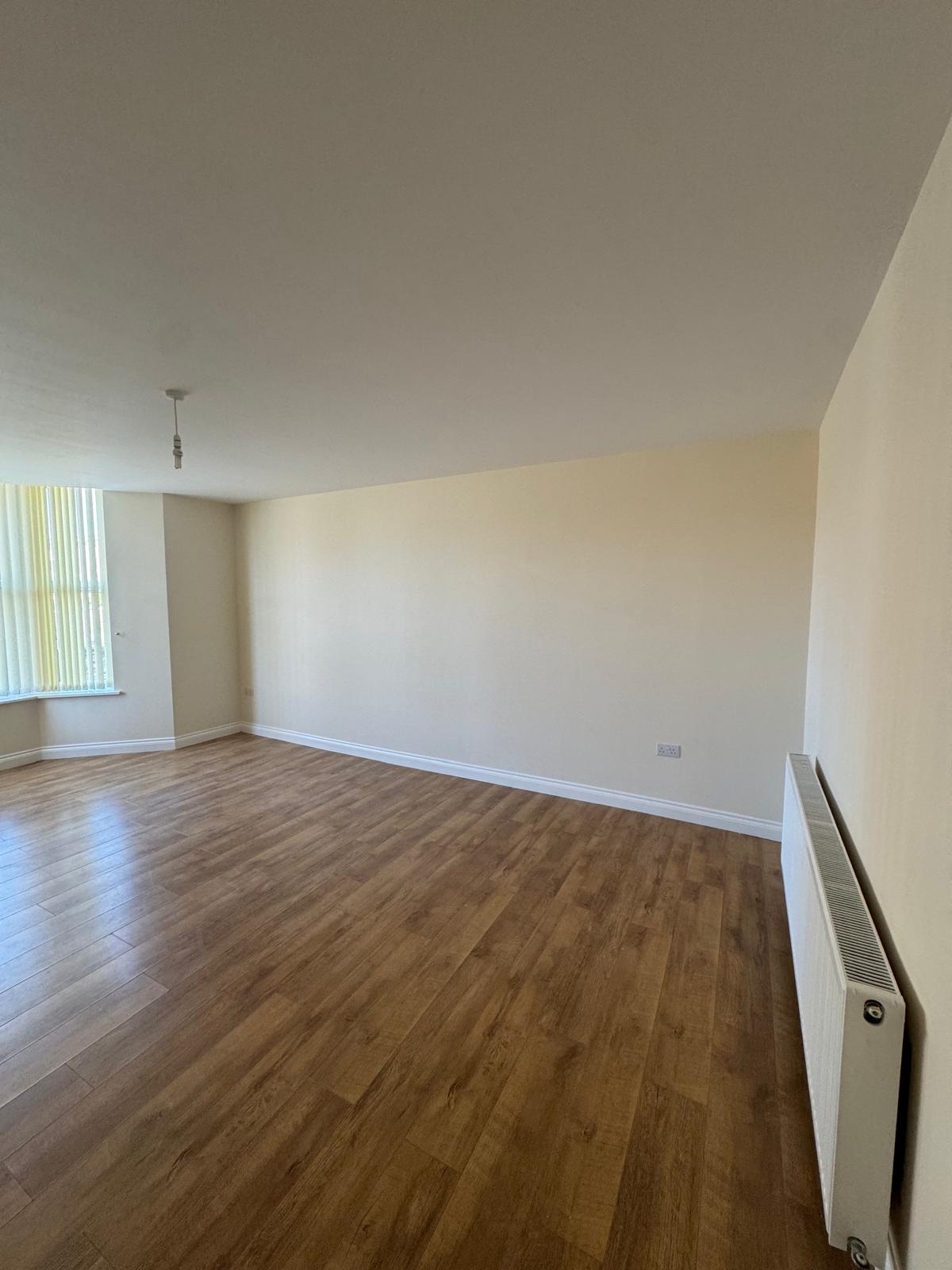 Large room with cream walls and flooring