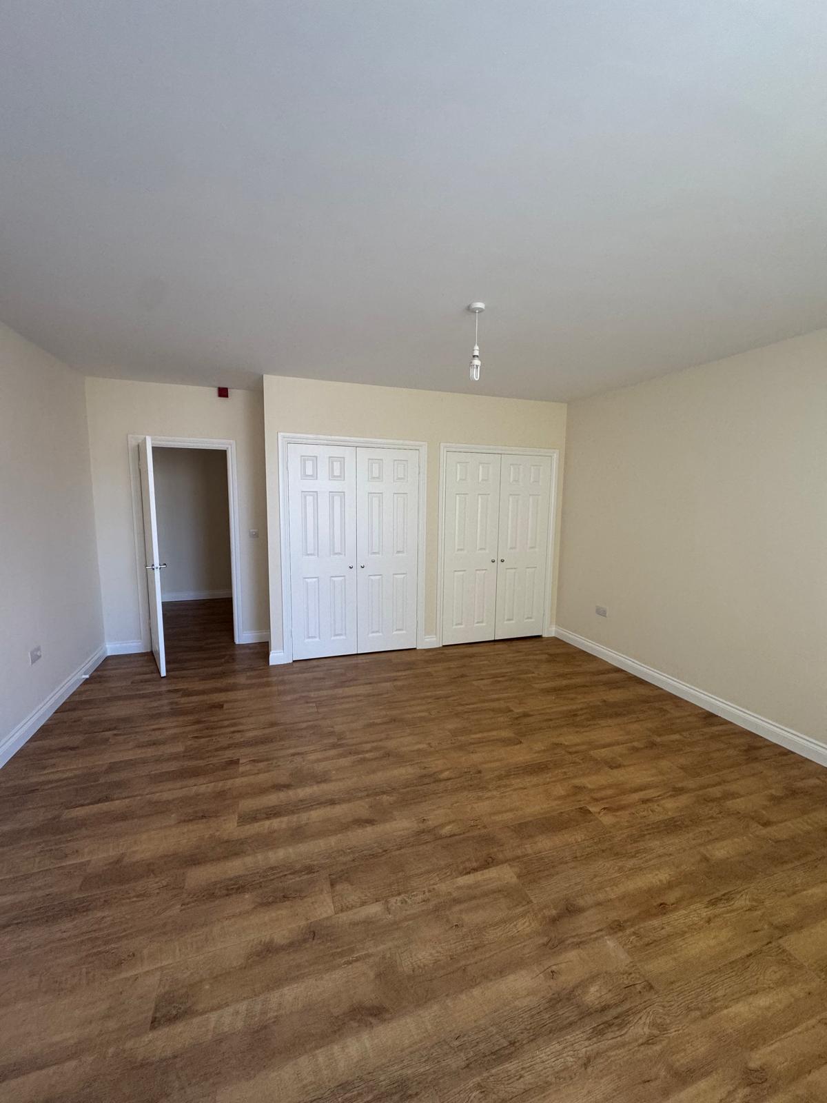 Bedroom with cream walls and built-in wardrobes